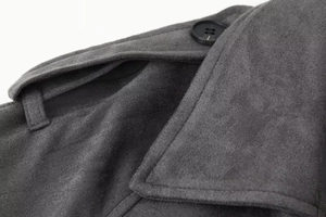 Detailed close-up of dark grey wool coat featuring black buttons and shoulder epaulettes
