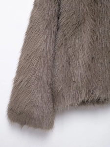 Close-up of the plush texture and soft taupe faux fur fabric on a short jacket hem