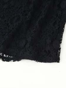 Close-up of black floral lace fabric with detailed hollow embroidery and scalloped edges