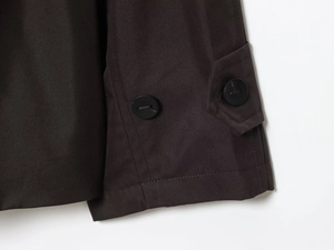 Close-up of waterproof parka coat cuff with dark brown twill fabric and matte black buttons
