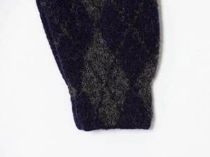 Detailed macro view of the purple diamond knit pattern and fluffy mohair wool texture