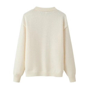 Gros plan du cardigan en maille blanc crème montrant les poignets et l'épaule tombante