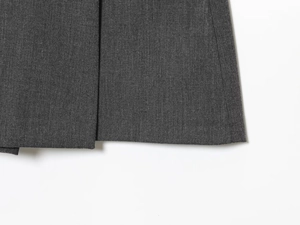 Détail de l'ourlet plissé et de la texture du tissu gris sur cette jupe-culotte décontractée