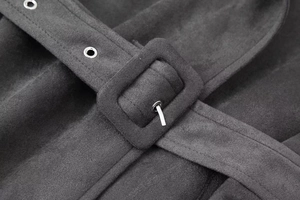Detail view of charcoal wool coat fabric with belt buckle and metal eyelets