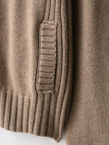 Close-up of brown knit cardigan showing ribbed hem and side pocket texture detail