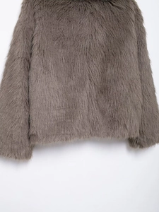 Detailed macro view of dark brown faux fur texture and wide sleeve hem of the coat