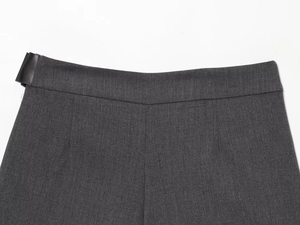 Détail de la jupe-short plissée gris foncé avec taille lisse et boucle décorative en cuir