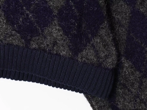 Close-up of deep purple diamond pattern knit cardigan with soft mohair texture