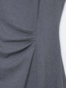 Detail of grey midi dress fabric showing pleated side seam and woven texture