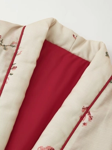 Close-up of kimono-style jacket with cream geometric print and red silk lining