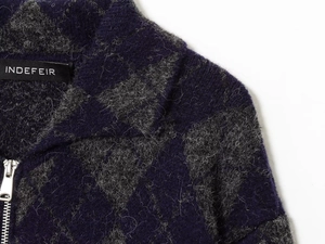 Detailed view of dark blue geometric knit cardigan featuring polo collar and silver zipper