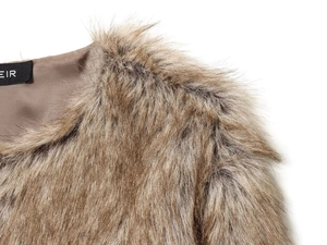 Detail of dark brown faux fur jacket neckline featuring smooth inner lining and brand tag