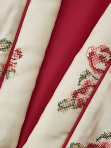 Detailed close-up of vintage red rose embroidery and red piping on cotton kimono jacket