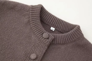 Gros plan d'un cardigan en maille taupe avec col rond et boutons recouverts assortis