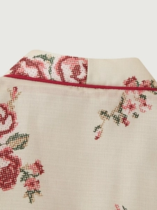 Detailed close-up of beige cotton kimono collar with pixelated floral print and red piping