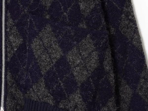 Detail of argyle knit cardigan with fuzzy texture and silver metallic zipper closure