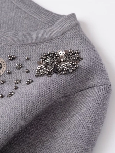 Macro shot of grey hand-beaded cardigan with metallic sequins and tube bead details