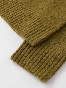 Close-up of olive green knitted sweater featuring classic rib-knit texture and soft fabric