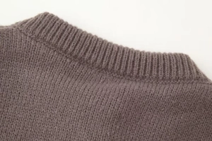 Détail du col rond côtelé et de la maille douce sur ce cardigan marron pour femme