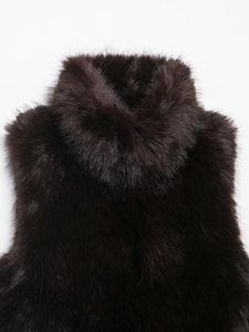 Close-up of fluffy dark brown faux fur vest featuring a luxurious thick stand collar