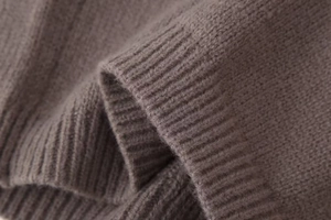 Gros plan sur la maille fine et les finitions côtelées du cardigan de couleur taupe