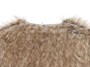 Detail shot of brown faux fur texture and inner size S label on a short jacket