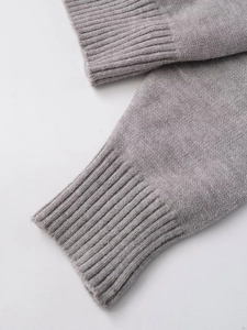 Detailed macro view of the elastic ribbed cuffs on a soft light grey knit cardigan