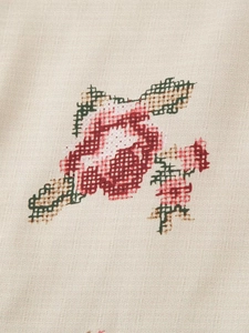 Macro shot of embroidered floral patterns on beige cotton kimono jacket fabric