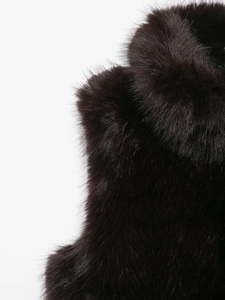 Close-up detail of luxurious dark faux fur vest showing dense and smooth texture