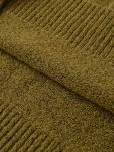 Close-up of thick mustard yellow knit fabric showing ribbed texture and soft wool fibers