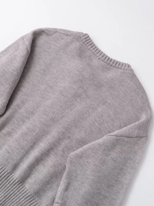 Detailed close-up of soft light grey knit sweater showing neckline and ribbed textures