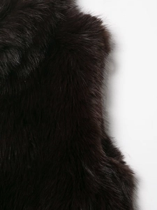 Detailed macro shot of dark faux fur texture on a minimalist sleeveless vest