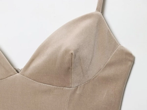 Détail de la robe en velours champagne avec fines bretelles et couture du décolleté en V