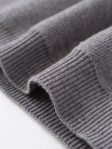 Macro shot of grey knit cardigan showing detailed ribbed cuffs and premium texture
