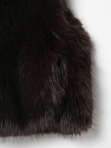 Close-up of fluffy dark brown faux fur texture with thick and soft long synthetic hair