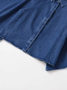 Detailed close-up of dark indigo denim shirt texture with buttons and stitching details