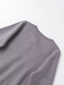 Detail view of a grey knit cardigan with delicate hand-beaded texture and soft fabric