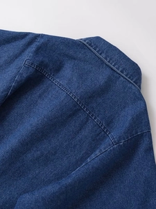 Detail of vintage navy blue denim shirt showing the collar, seam stitching and fabric texture