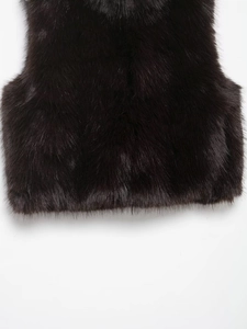 Close-up of deep black faux fur vest showing soft fiber texture and high-quality shine