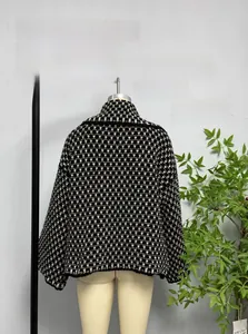 Detail of black and white checkered knit cardigan with ribbed cuffs and relaxed fit