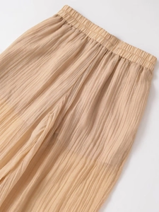 Detail of high waist elastic waistband and vertical pleated texture on wide-leg trousers