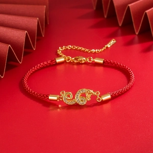 Detail of red braided dragon bracelet with sparkling zircon inlay and gold clasp
