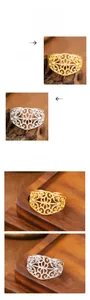 Macro shot of intricate hollow flower patterns on 18K gold and silver plated steel rings