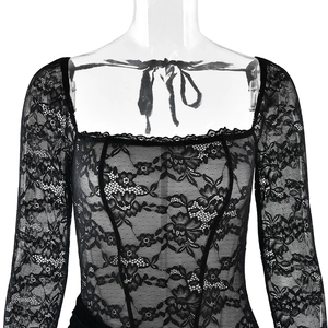 Close-up of elegant black lace dress with square neckline and floral embroidery details