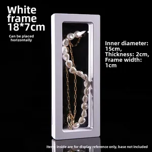 Detail of white 18x7cm PE film floating jewelry display frame showing dimensions and texture