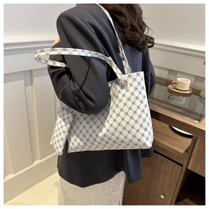 Detail of white printed tote bag with matching coin purse shown on shoulder
