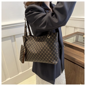 Brown vintage printed tote bag with inner pouch shown on shoulder in office setting