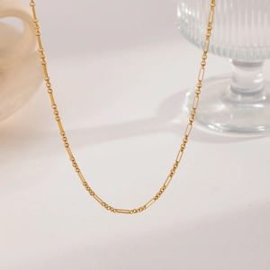 Detail of elegant gold titanium necklace featuring alternating rectangular and round links