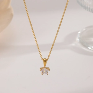 Macro detail of a gold pentagram pendant necklace featuring a clear center gemstone