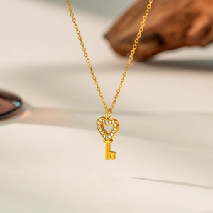 Detail of a gold heart-shaped key pendant with sparkling pavé-set cubic zirconia